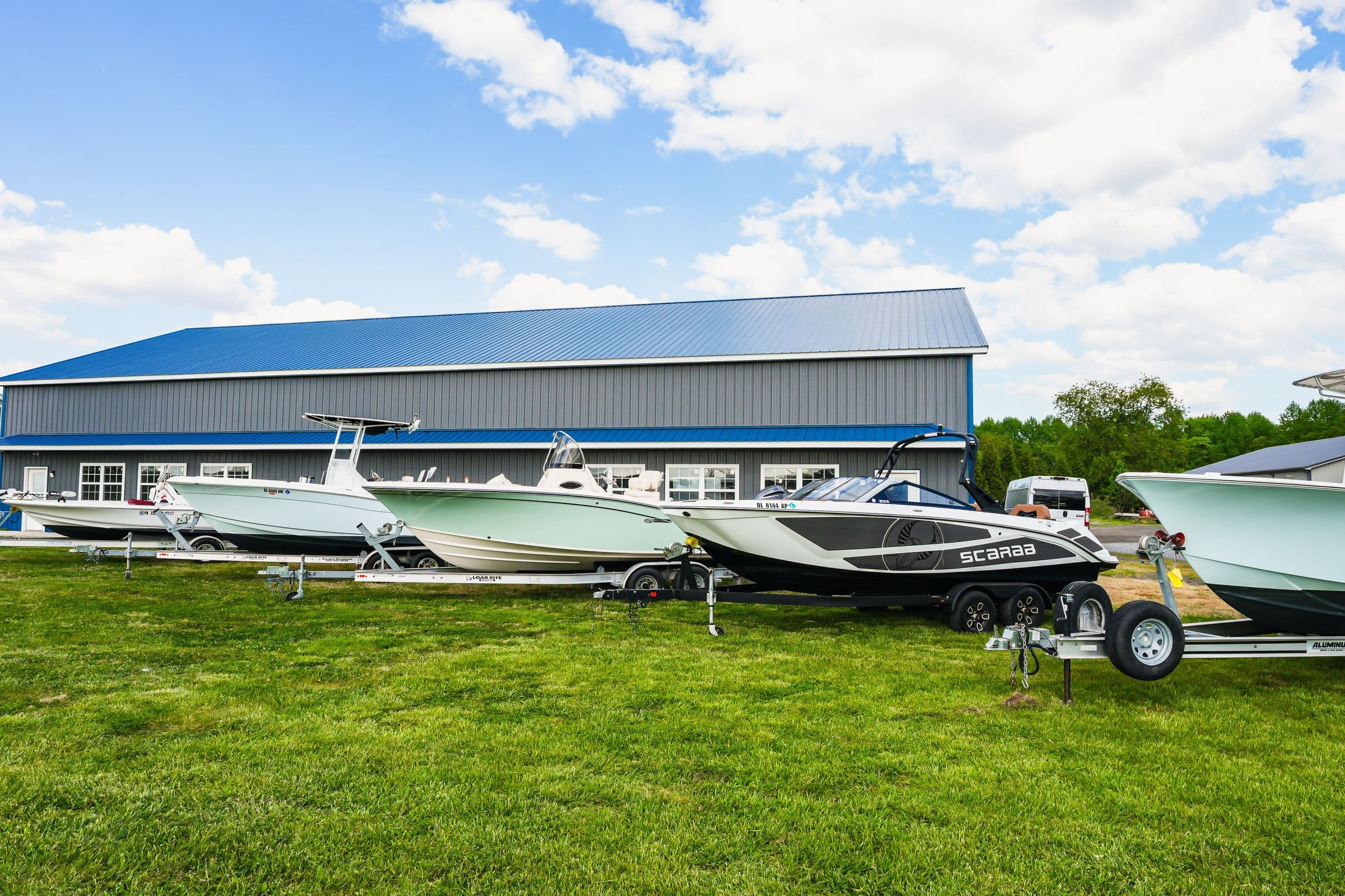 Delmarva Service Center's marine repair facility at 18473 Harbeson Road, Milton, Delaware, with customer boats staged on the lawn