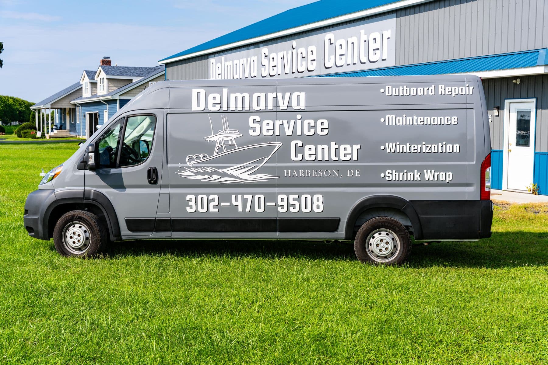 Side profile of the Delmarva Service Center mobile service van, showing the boat line-art logo, the services list, and the shop phone number