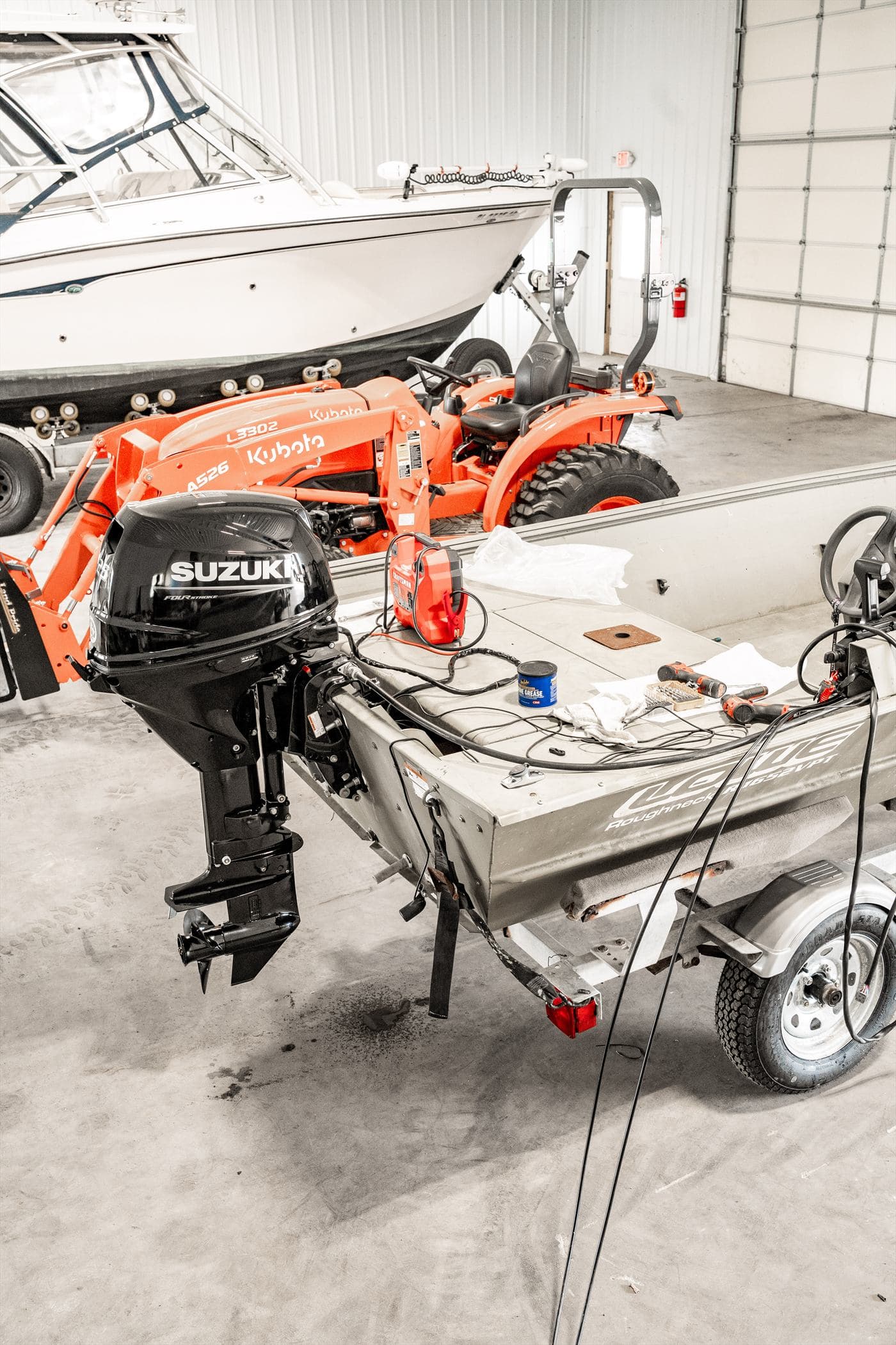 Outboard engine on a boat in the service bay alongside shop equipment